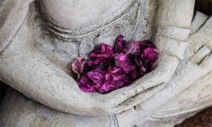A photo of a Buddha statue holding flowers