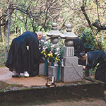 Photo of Tangen Roshi making an offering to Harada Roshi’s grave
