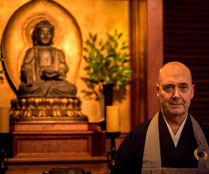Photo of Roshi Bodhin Kjolhede in front of an altar with a Buddha figure